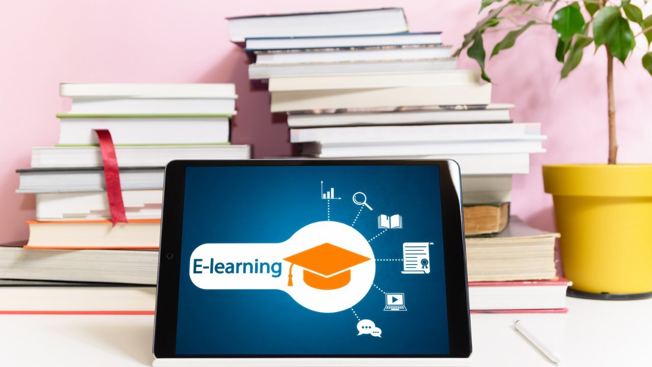 Tablet on a desk with some books to the post tools for online learning